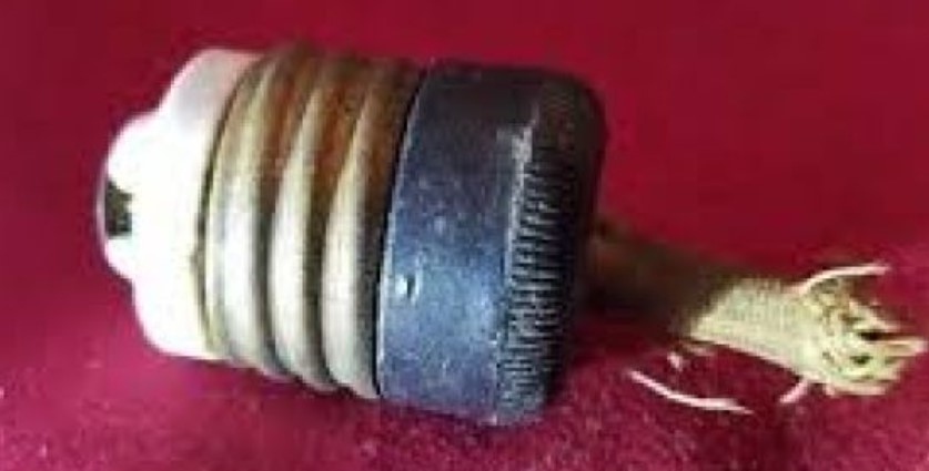 Old electrical socket against a red background.