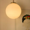 Glowing pendant lamp above artwork.