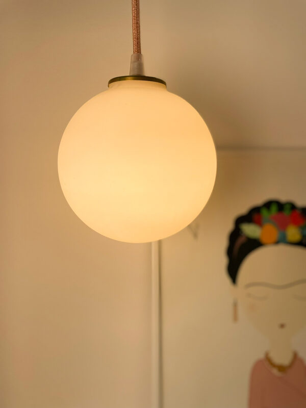 Glowing pendant lamp above artwork.