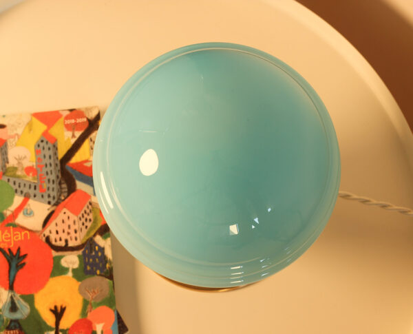 Bol bleu sur table avec nappe colorée.