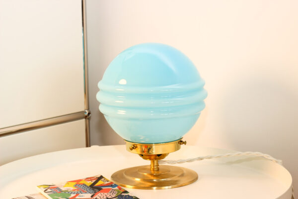 Lampe vintage bleue sur table de nuit.