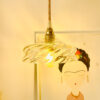 Hanging light above illustrated wall art. Artistic hanging lamp with a glass globe mounted on a brass socket above a wall drawing.