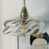 Hanging light above illustrated wall art. Artistic hanging lamp with a glass globe mounted on a brass socket above a wall drawing.