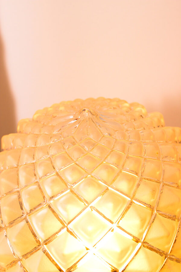Globe en verre dépoli et ciselé allumé avec une pointe en son dessus.