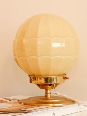 Art deco style illuminated table lamp. Table lamp composed of a spherical yellow vintage glass globe.