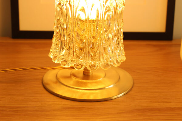 Lampe à poser vintage composée d'un globe en verre cylindrique de fabrication par moulage. La base est en laiton brossé.