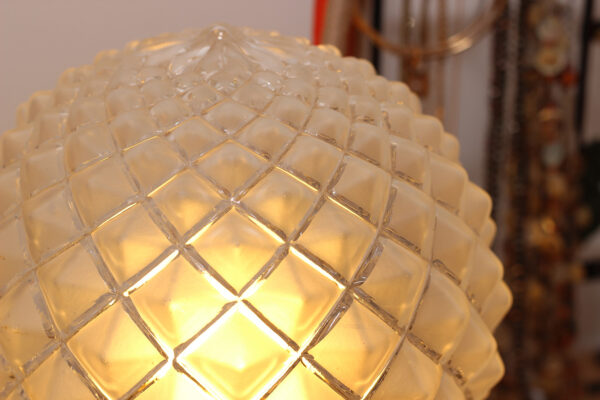 Le globe en verre est allumé. Il est composé de marque de ciselage et sur chaque pointe est dépoli.