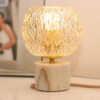 Lampe à poser Vintage composée d'un globe en verre ciselé et d'une base en marbre blanc et veines beiges.