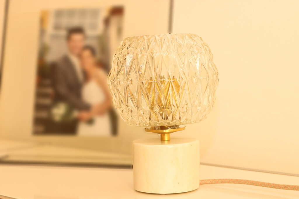 Lampe à poser Vintage composée d'un globe en verre ciselé et d'une base en marbre blanc et veines beiges.