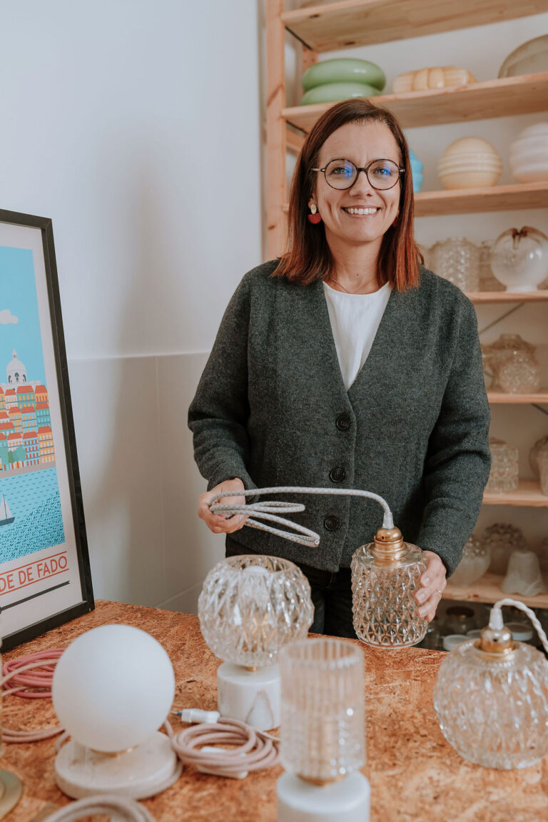 Femme souriante tenant des lampes vintage.