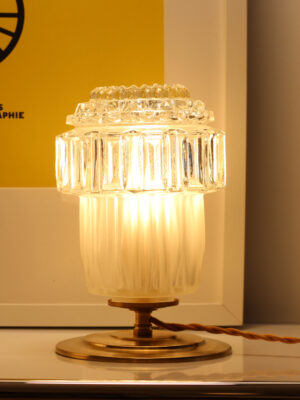 Clara vintage table lamp by Alfama Chic lit up — dual-texture glass globe with fluted frosted lower section and clear pressed glass upper section, on golden brass base