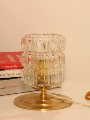 Candeeiro de mesa vintage Gabriela da Alfama Chic — vidro moldado-prensado com motivos geométricos sobre base em latão dourado polido, colocado numa secretária com livros