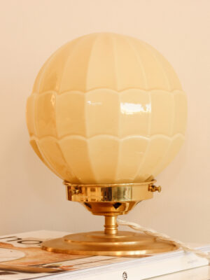 Lampe à poser vintage Juliette par Alfama Chic — vue rapprochée du globe sphérique en opaline crème à motifs écailles sur coupelle et base en laiton doré poli avec câble textile torsadé blanc