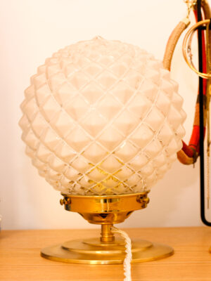 Candeeiro de mesa vintage Raphaèle da Alfama Chic — vista aproximada do globo esférico em vidro fosco cinzelado com motivos losangos em relevo sobre suporte e base em latão dourado polido