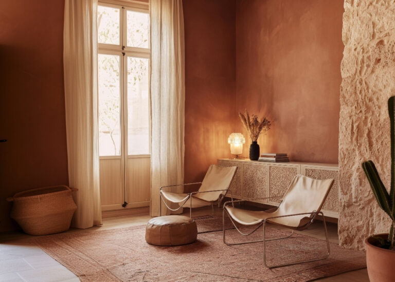 Bright living room with walls painted in Mocha Mousse (PANTONE 17-1230), caramel leather armchairs, leather pouf, marble side table, and vintage cut-glass lamp – Alfama Chic.